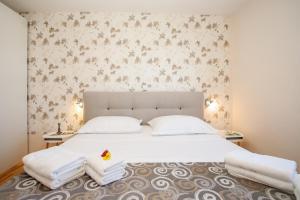 a bedroom with a large white bed with two pillows at Villa Plaža in Zavala