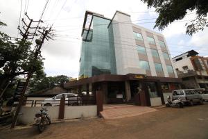 a building with a motorcycle parked in front of it at Hotel Rajdoot Royale by Ambai in Ichalkaranji