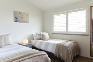 1 dormitorio con 2 camas y ventana en Byron Quarter Apartments en Byron Bay