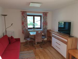 a living room with a red couch and a tv at Haus 66 in Obertraun