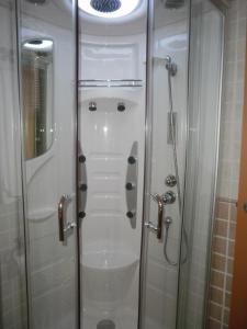 baño con ducha y puerta de cristal en Hostal El Olmo en Camarena de la Sierra