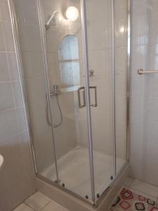 a shower with a glass door in a bathroom at Panoráma Üdülőszálló in Sopron