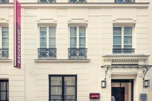 a white building with windows and balconies at Mercure Paris Arc de Triomphe Wagram in Paris