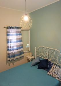 una camera con letto blu, lampada e finestra di Casa Azzurra a Bagheria