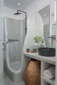La salle de bains est pourvue d'une douche et d'un lavabo. dans l'établissement Perla Suites, à Pollonia