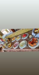 una mesa con diferentes tipos de comida en platos en Pousada Toca do Tato, en Natal
