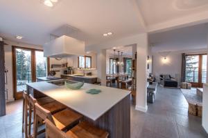 uma cozinha e sala de estar com uma grande ilha com cadeiras em Unique Chalet avec vue a 360 degres - LLA Selections by Location Lac Annecy em Doussard