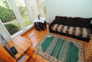 a living room with a couch and a table at Palangos Saulegraza in Palanga +7 photos