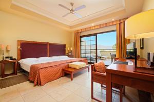 Una habitación de hotel con una cama, un escritorio y un dormitorio. en Hotel Envia Almería Spa & Golf, en Aguadulce