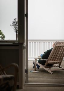 a person sitting in a rocking chair in a room at Helenekilde Badehotel in Tisvildeleje