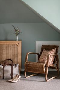 a room with a rattan chair and a table at Helenekilde Badehotel in Tisvildeleje