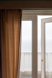 a room with two windows and a curtain at Helenekilde Badehotel in Tisvildeleje