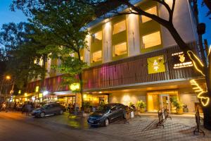 two cars parked in front of a building at night at Fountain Tree by TGI in Bangalore