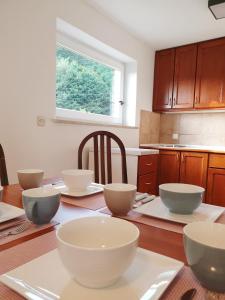 - une cuisine avec des bols blancs sur une table en bois dans l'établissement Apartment Barje I, à Ljubljana