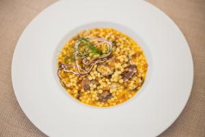 a white plate with a bowl of food on a table at Hotel Aquadulci in Chia