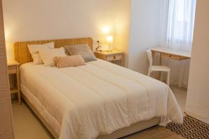 Un dormitorio con una gran cama blanca y una mesa en Casa Cal Music, en Altea
