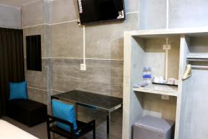 a room with a table and a chair and a television at Bangkok 68 in Bangkok