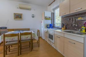 a kitchen with a table and a sink and a counter at Ivan&Anka Selce apartments in Selce