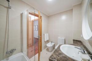 une salle de bain avec un lavabo, une douche et des toilettes dans l'établissement Reis Magos III by An Island Apart, à Caniço 21 autres photos