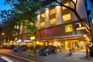 two cars parked in front of a building at night at Fountain Tree by TGI in Bengaluru