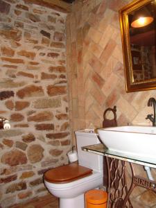 uma casa de banho em pedra com um WC e um lavatório em CASA RURAL EL HAYEDO em Pineda de la Sierra