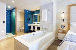 a large bathroom with a tub and a bed at Gran Tacande Wellness & Relax Costa Adeje in Adeje