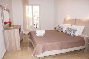 a bedroom with a large bed with a mirror and a dresser at Erosea Beach Resort in Kavos +36 photos