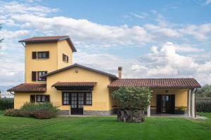 a yellow house with a green yard at Residenza Paradisea in Arezzo