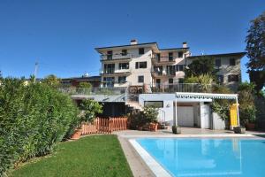 a house with a swimming pool in front of a building at Casa Montegolo in Costermano