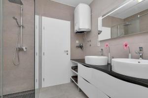 a bathroom with two sinks and a shower at Luxury apartment Macola Free beach parking in Makarska +31 photos