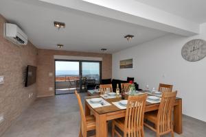 a dining room with a table and chairs and a clock at Luxury apartment Macola Free beach parking in Makarska