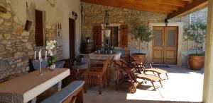 patio z krzesłami, stołem i kamienną ścianą w obiekcie Rooms & Apartment STELIO w mieście Loborika