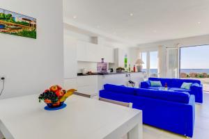 a living room with a blue couch and a white table at Beachfront Apartment Migjorn Playa in Colònia de Sant Jordi