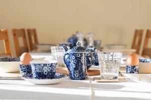 a table with blue and white china and eggs and glasses at Leverton House in Cambridge