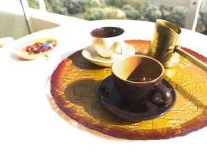 einen Teller mit zwei Tassen Kaffee auf dem Tisch in der Unterkunft Thomas Hotel in Monólithos