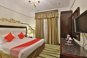 سرير أو أسرّة في غرفة في OYO 335 Manazil Al Ain Grand Hotel