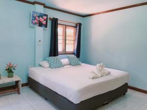 a bedroom with a large white bed with a window at River Kwai Park & Resort in Chongsadao
