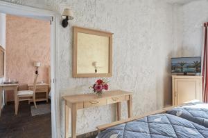 Un dormitorio con una mesa con flores. en Andros Holiday Hotel, en Gavrion