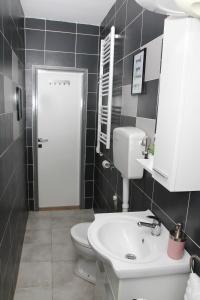 een badkamer met een witte wastafel en een toilet bij Apartman Zen in Osijek