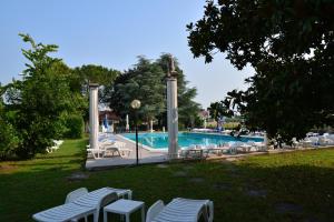 a swimming pool with lounge chairs and a swimming pool at Affittacamere Villa Serafini in Remanzacco