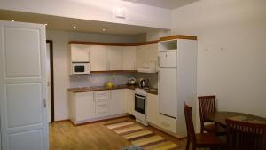 a small kitchen with white cabinets and a table and a tableablish at Ruskalinna Apartments in Pello