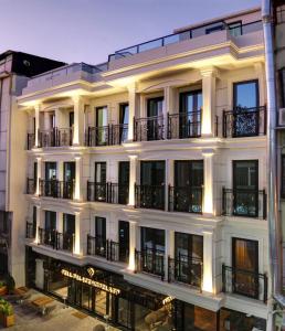 a large white building with balconies and lights at Pell Palace Hotel & SPA in Istanbul