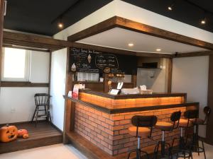 札幌市にあるSapporo Guest House 庵 Anneのレンガ造りのカウンターとスツール付きのレストラン