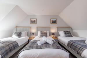 sypialnia na poddaszu z 2 łóżkami pojedynczymi i 2 lampami w obiekcie The Steadings - by StayDunfermline w mieście Dunfermline