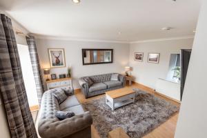 a living room with a couch and a table at The Steadings - by StayDunfermline in Dunfermline