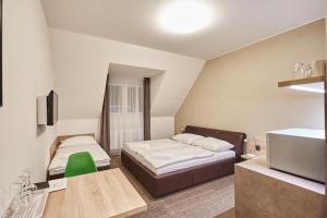 um pequeno quarto com 2 camas e uma televisão em Apartmány Volarik em Mikulov