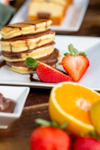 a plate of pancakes and strawberries on a table at Pavlos Hotel in Kos Town