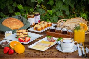 a table topped with sandwiches and fruit and a cup of coffee at Pavlos Hotel in Kos Town