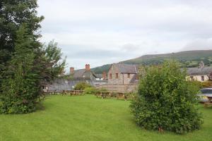 un gran patio con mesas de picnic y un edificio en Dragon Inn, en Crickhowell