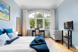 1 dormitorio con cama, escritorio y ventana en Elite Apartments Sopot Admiralski przy plaży, en Sopot